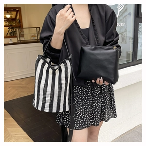 Detail of striped mesh bucket bag set with black leather straps and matching inner pouch