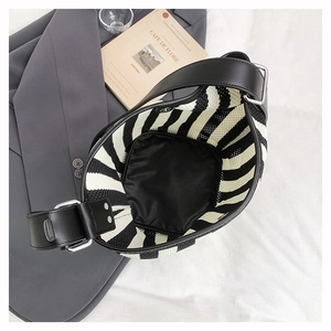 Detail view of striped mesh tote bag with wide leather strap and spacious interior