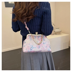 Détail de la broderie de pivoine rose et de l'élégante poignée en perles du sac vintage
