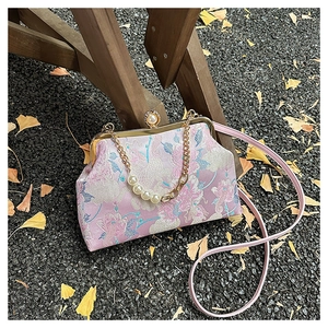 Détail de broderie florale sur sac cheongsam vintage avec fermoir perle et chainette