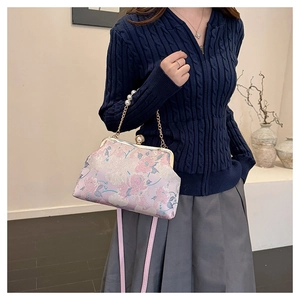 Détail d'un sac à main cheongsam vintage avec broderie florale et fermoir perle