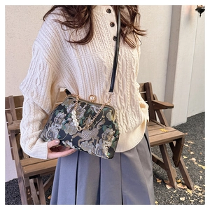 Détail d'une pochette jacquard rétro avec fermoir perle et broderie de phénix élégante