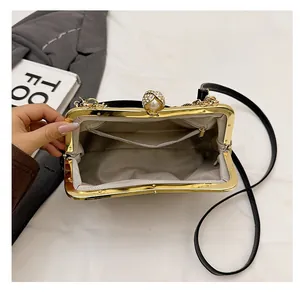 Détail de l'intérieur d'une pochette noire avec poche zippée et fermoir en perle