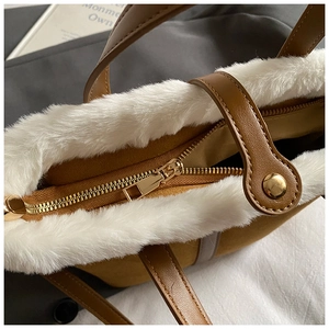Detailed close-up of the brown faux leather bag with white plush trim and golden zipper