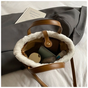 Detail view of brown leather bag with white faux fur trim showing interior cosmetic storage