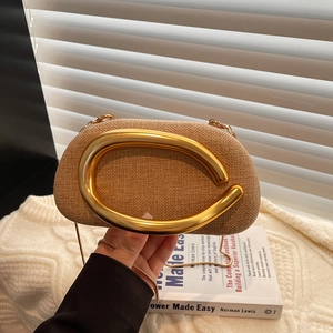 Retro woven straw shoulder bag with oversized gold C-shaped handle and metal chain