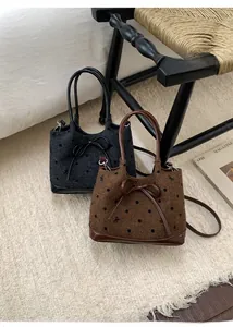 Sacs seaux à pois noirs et marrons posés sur un tapis doux au décor vintage