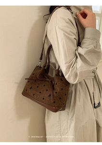 Sac seau en toile à pois avec nœud, porté par un mannequin en trench-coat beige