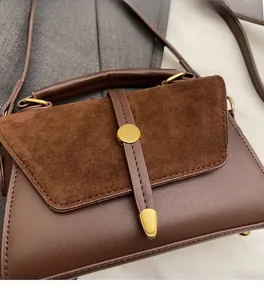 Dettaglio borsa a mano marrone retrò con texture opaca e fibbia dorata circolare