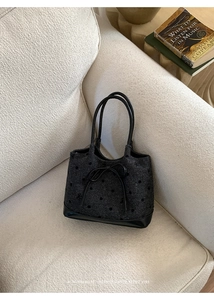 Détail d'un sac à main rétro noir avec nœud en cuir et motifs à pois discrets