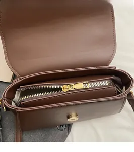 Dettagli dell'interno della borsa marrone opaca con cerniera dorata e chiusura magnetica