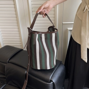 Green and brown striped woven tote bag with adjustable brown leather shoulder straps