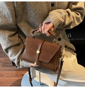 Dettaglio della borsa a tracolla marrone vintage con trama opaca e fibbia dorata