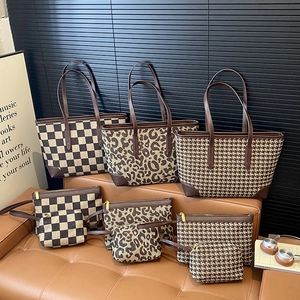 Three-piece leopard and checkered tote bag sets with matching pouches on a brown sofa