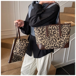 Three-piece set detail showing leopard print canvas tote, pouch, and wristlet set