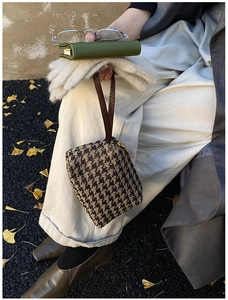 Classic houndstooth patterned tote bag with brown leather strap and gold zipper details