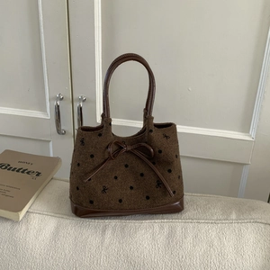 Polka dot bucket bag with bow embroidery and brown leather trim for casual style