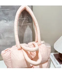Detail view of pink quilted puffer tote bag with thick padded shoulder straps and soft texture