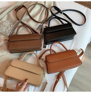 Flat lay of vintage square leather handbags in four colors with adjustable shoulder straps