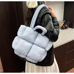 Macro shot of light blue puffy quilted shoulder bag in a modern kitchen setting