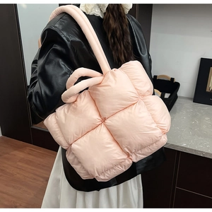 Close-up of pink quilted puffer tote bag shoulder straps and soft texture detail