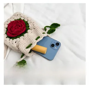 Interior capacity of handmade floral crochet bag showing phone and lipstick storage