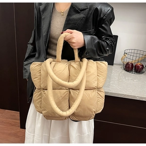 Detail of khaki quilted puffer tote bag with thick padded handles and spacious interior