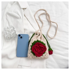 Detailed close-up of handmade crochet flower bag with 3D red rose and drawstring closure
