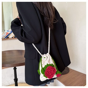 Detail of handmade crochet crossbody bag with 3D red rose flower and leaf applique