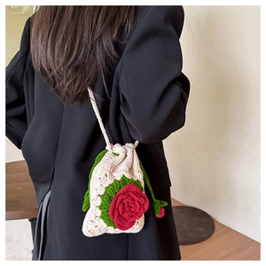 Detail of handmade crochet shoulder bag featuring a 3D red rose and green leaf design
