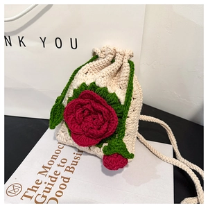 Close-up of handmade crochet bag featuring 3D red rose and green leaf embroidery