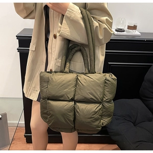 Detailed close-up of large olive green quilted tote bag with soft padded texture