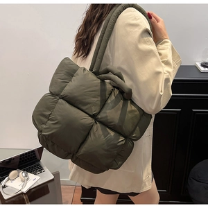 Detail of army green quilted puffer bag showing the oversized woven texture and padded strap