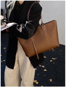Détail de la texture en cuir tressé et des longues anses du sac cabas marron
