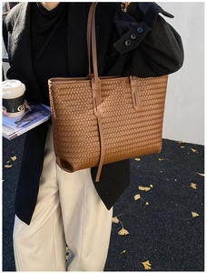 Détail du sac cabas tressé marron foncé avec texture fine et fines bandoulières