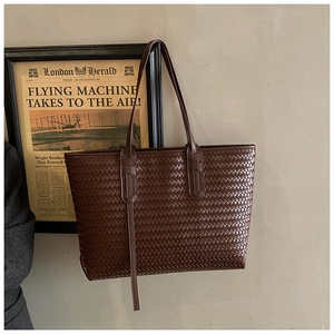 Détail du sac cabas tissé marron foncé avec texture cuir et style intérieur rétro chic