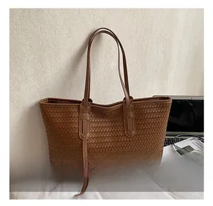 Détail d'un grand sac cabas marron avec un tissage en cuir élégant et un style vintage