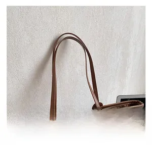Détail de la poignée du sac cabas marron tissé et de la texture du matériau