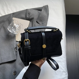 Borsa a tracolla in pelle nera opaca con dettagli dorati su sfondo bianco