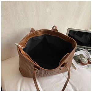 Vue détaillée du grand sac cabas tressé marron avec doublure noire et poche zippée