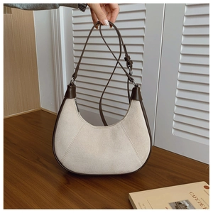 Detail of hobo crescent bag with cream suede texture and brown leather strap and trim