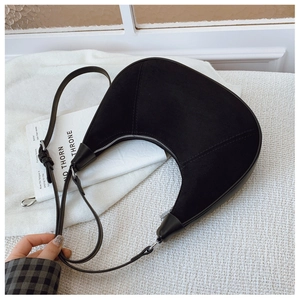 Close-up of black suede hobo bag with smooth leather trim and silver zipper detail