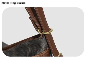 Détail de la bandoulière en cuir marron avec anneau en métal doré sur un sac fourre-tout
