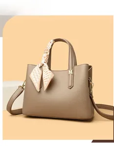 Dettaglio della borsa tote beige in pelle martellata con foulard e ciondolo M