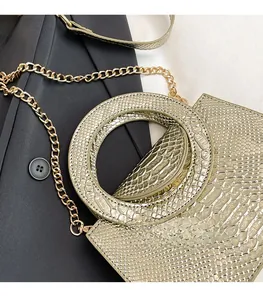 Détail du sac à main texture serpent avec poignée ronde dorée et bandoulière chaîne