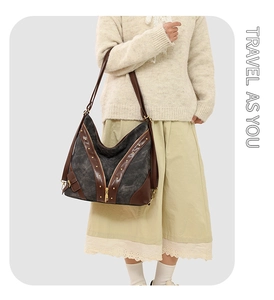 Détail de la toile et du cuir brun avec des rivets dorés sur un grand sac cabas
