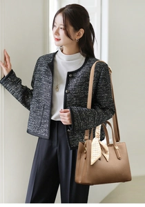 Dettaglio borsa tote in pelle marrone con foulard a cuori e finiture in metallo oro