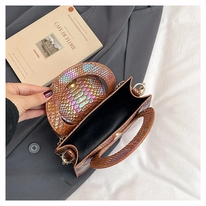 Vue détaillée du sac marron texture serpent avec chaîne dorée et détails irisés
