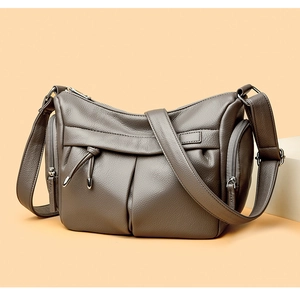 Dettaglio della borsa a tracolla in pelle grigio scuro con design a tasche multiple