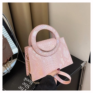 Détail du sac à bandoulière rose perlé avec gaufrage serpent et poignée ronde en métal